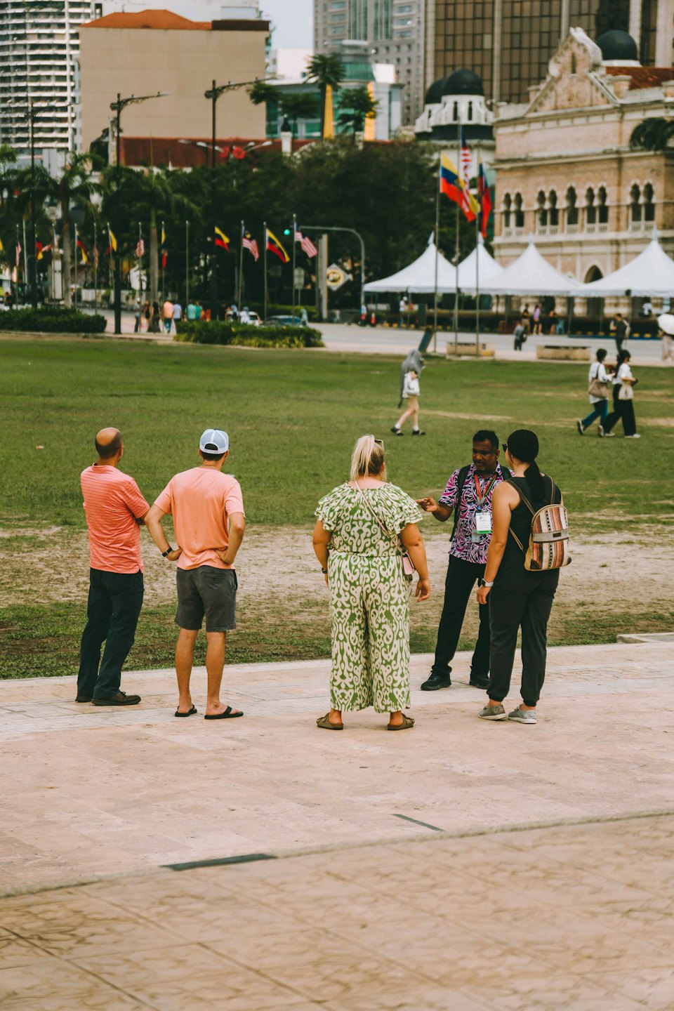 Un guía turístico habla con un grupo de turistas en un parque.